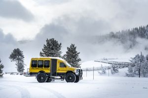 Snowcoach parked at snow-covered Black Sand Basin