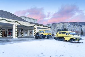 Mammoth Hot Springs Hotel exterior in winter with snowcoach parked outside