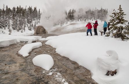 Cross-country skiers watch a Lone Star Geyser eruption