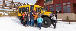 Group photo in front of Snow Lodge with snowcoach