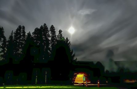 night photo of lunar halo with lighted building