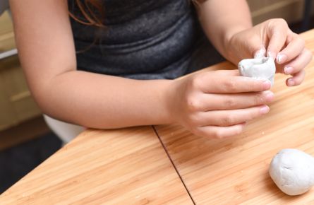 Girl making pottery with white clay